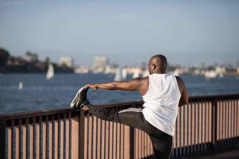 African American man stretching by the water, promoting outdoor fitness and healthy lifestyle.